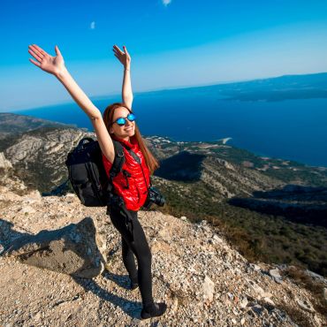 Person jumping on mountain peak